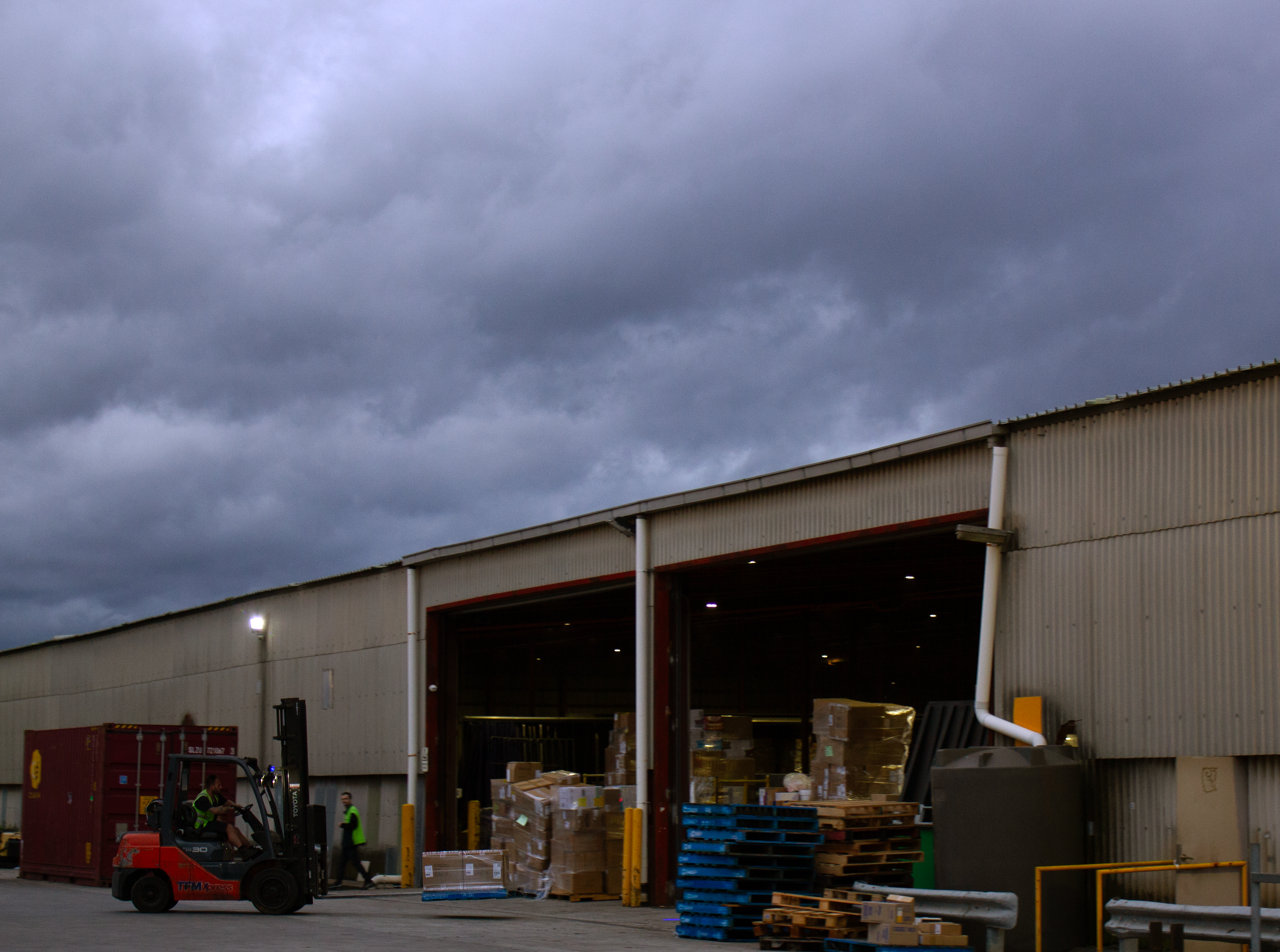 Forklifts working under a cloudy winter sky